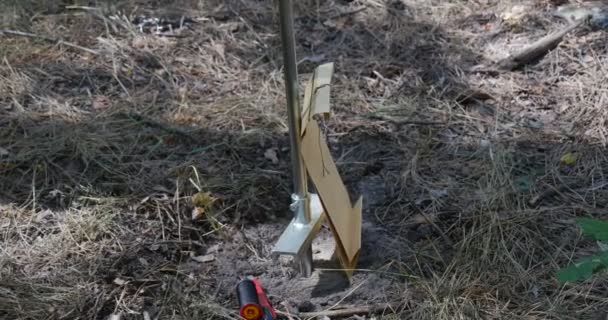Бумажный пакет, катушка нитей, нож и ручной держатель, размещенный на лесной почве недалеко от хранилищ нефти летом — стоковое видео