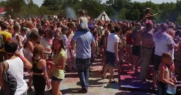 Wielobarwny tłum młodych ludzi przyjęć, podczas gdy uczestniczy festiwal kolorów w Kijowie w lecie — Wideo stockowe