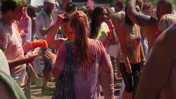 Happyc Girls and Boys dançando e levantando as mãos, enquanto visitam um festival sagrado de cores, organizado pela comunidade indiana em Kiev em Sumer, em câmera lenta — Vídeo de Stock
