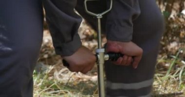 Adam biraz yağ depolama için bitişik topraklarının kimyasal kirlilik düzeyini kontrol etmek planlama bir orman, onun Metal el ayraç döner