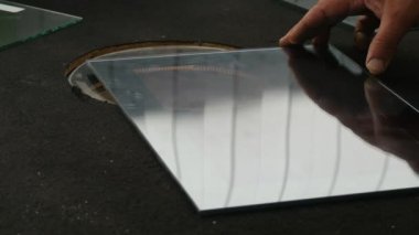 Closeup çekim bir kurşun geçirmez Cam, cam denetim bir laboratuarda üreten bir uzman eller tarafından cihaz test bazı yuvarlak cam üzerine taşındı bir levha