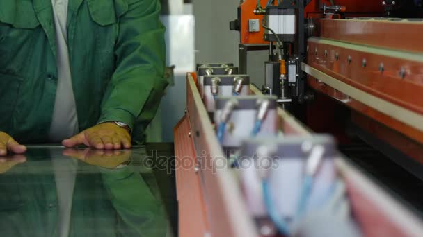 A High Skilled Specialist in Green Uniform Works on a Production Lane of Bulletproof Glass and Using Grange Machine, in a Special Workshop — Stock Video