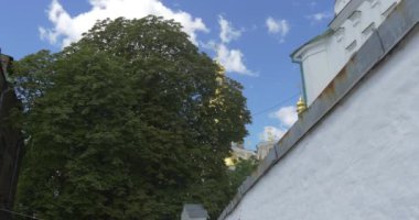 Kiev Pechersk Lavra için yaz aylarında gündüz ait çok yüksek yeşil ağaç üzerinde bölge, Uspensky Sobor,