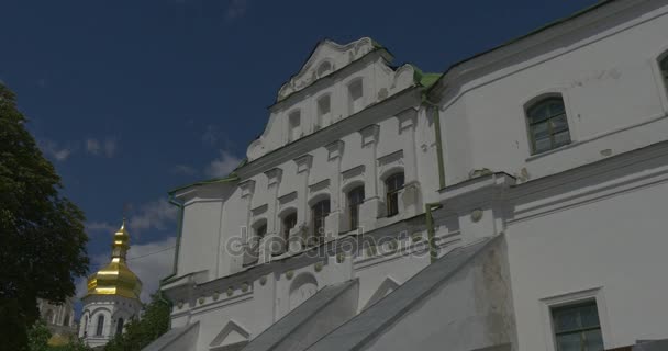 Abajo arriba Shot of Uspensky Sobor of Kiev Pechersk Lavra con sus antiguos edificios y grandes y pequeñas cúpulas de oro en verano — Vídeo de stock