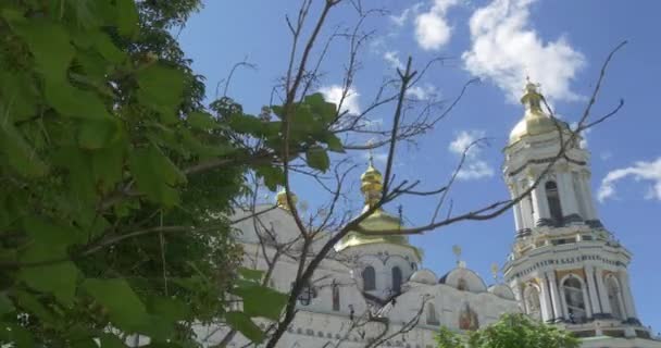 Kiev Pechersk Lavra y un árbol de edad alta a través de las hojas de los cuales el tiro hacia abajo de Uspensky Sobor se hace en verano — Vídeos de Stock