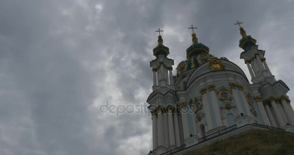 Fabelhafte vordere Säulen und drei goldene Zwiebeln aussehende Kuppeln der Heiligen-andrew-Kirche in der historischen Nachbarschaft Podil, bei bewölktem Wetter — Stockvideo