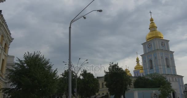 古い成形と曇りの天候で印象的なアーチで覆われて、青い壁と勲章の黄金ドーム修道院の鐘塔の左のショットを追跡 — ストック動画