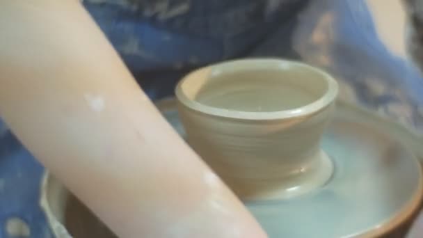 An Apprentice and a Master Make a Nice Clay Craft Looking Like a Future Cup, Using a Special Scrapes and a Moving Wheel in a Pottery Workshop — Stock Video