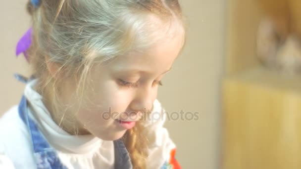 Un artículo de arcilla está hecho por una niña rubia Aprentice con una blusa blanca y un delantal azul, en algunos pequeños talleres en Polonia — Vídeo de stock