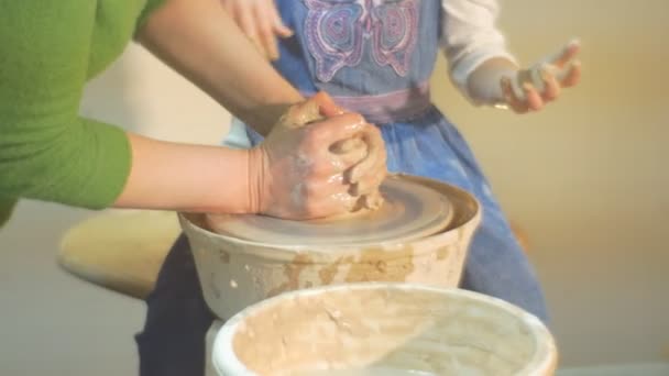 Ein Ton wird von einem mühevollen blonden Mädchen hergestellt, das in Polen das alte Töpferhandwerk erlernt und dabei von einem erfahrenen Meister unterstützt wird — Stockvideo