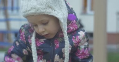 Altı yıl yaşında sarışın kız sonbahar Polonya oyun Park bölgesi giyinmiş bir renkli Waiscoat, örgü şapka ile Balabon, pembe pantolon içinde mevcuttur