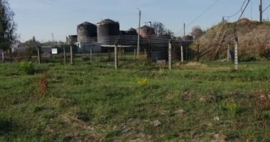 Yaz aylarında gündüz Behing çit beton direk ve Ukrayna, dikenli tel ile varlık gri renklerde çok büyük depolama rezervuarlar boyalı