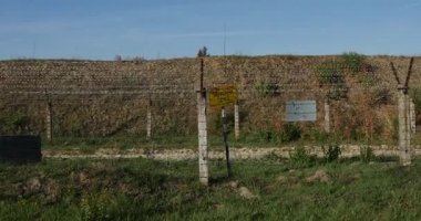 Kamera yaklaşan bazı sarı şarkı ile bir 'Yasak bölge' yazıt yüklü arkasında bazı dikenli Wite çit ve Ukrayna Gueard kulede