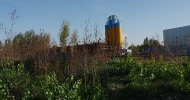 Gündüz yaz aylarında Ukrayna, bazı ahşap çit üzerinden yapışkanlık dışarı sarı ve mavi renklerde yüksek petrol depolama rezervuarlar boyalı