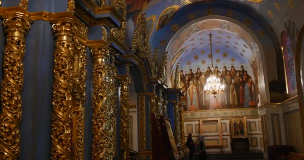 Gyllene tittar kolumner med Splendid gjutning och Saint ikoner i sidan av dem i den ortodoxa kyrkan tillhör Kiev Perchersk Lavra — Stockvideo