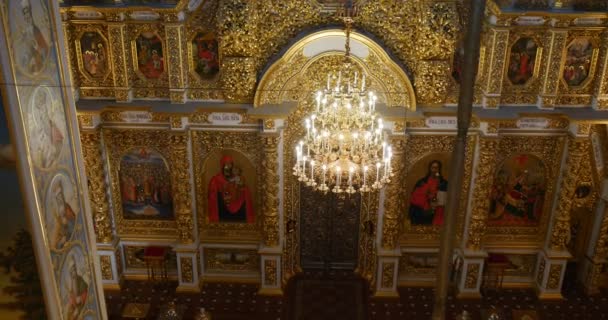 Zlatý lustr pohledu a nádhernou ikonostas s Saint Mary a jiných svatých v ortodoxní kostel patřící do Kyjeva Perchersk lávra — Stock video