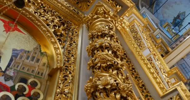 Hermosa Iconostasis de aspecto dorado con columnas cubiertas con talla y molduras en la iglesia que pertenece a Kiev Percherskaya Lavra — Vídeos de Stock