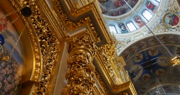 Enorme Iconostasis de aspecto dorado con columnas cubiertas con talla y molduras en la iglesia perteneciente a Kiev Percherskaya Lavra — Vídeo de stock