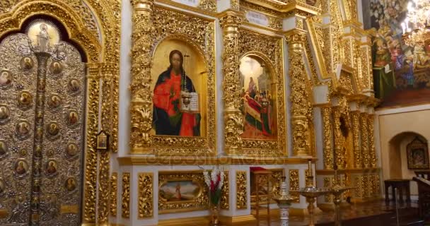 Огромный золотистый иконостас с колоннами, покрытыми резьбой и лепниной в храме, принадлежащем Киевской Перчерской лавре — стоковое видео