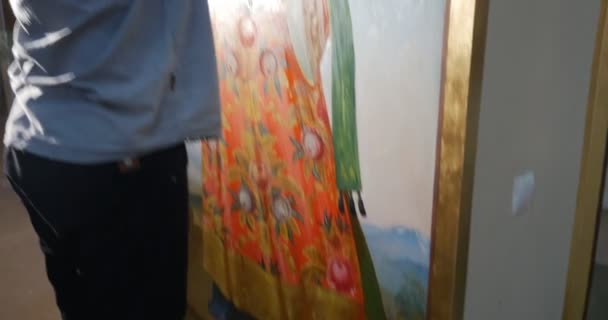 Реставратор, смешивает краски и обновляет что-то на иконе Пресвятой Богородицы, смотрящей вверх в храме, принадлежащем Киевской Перчерской лавре — стоковое видео