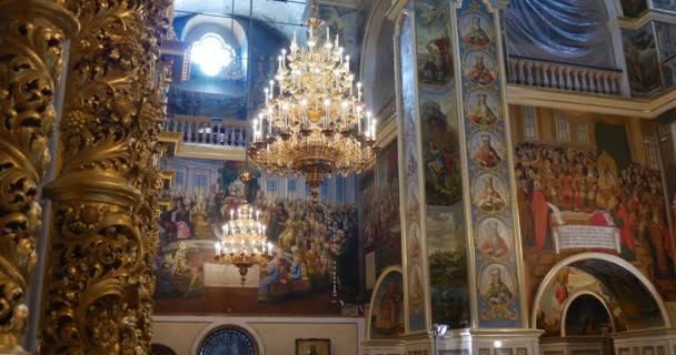 Fijn uitziende Columns en kroonluchter bogen met een heleboel beelden van heiligen in de christelijke kerk die naar Kiev Perchersk klooster in Oekraïne — Stockvideo