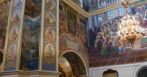 Leuke Columns op zoek en kroonluchter bogen met een heleboel beelden van heiligen in de christelijke kerk die naar Kiev Perchersk klooster in Oekraïne — Stockvideo