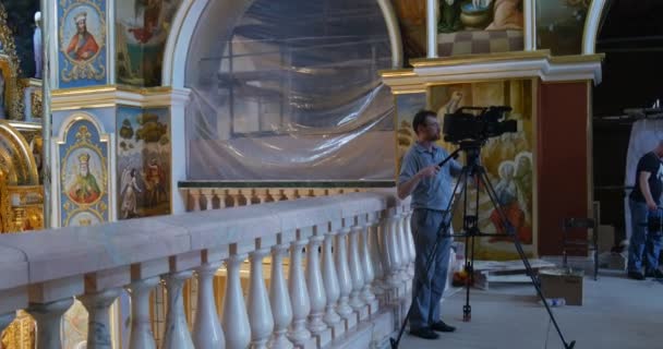 Fotoaparát muž s Steadicam a stativ střílí velký kostel Nanebevzetí Panny Marie v Kyjevě — Stock video