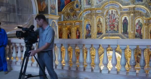 Mannen med ett kamerastativ är skytte Thegreat kyrkan av antagandet av den Jungfru Maria från andra våningen — Stockvideo