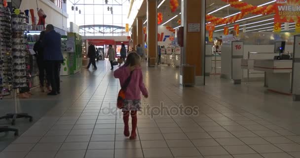 1er mai à Opole Little Girl Walking by Mall Grocery Store Kid regarde autour de lui Absently Les gens achètent des boissons alimentaires et des vêtements de haute qualité de vie — Video