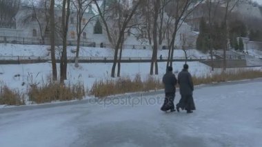 İki keşiş Sviatohirsk Lavra bulutlu soğuk gün yürüyüş boyunca Seversky Donets Nehri Snowy geçirerek peyzaj dağlık arazi çıplak dal ağaç