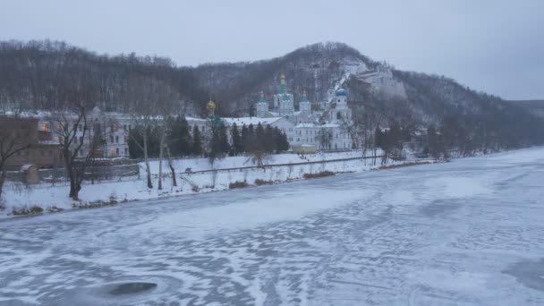 Vackra vinter synpunkt Sviatohirsk Lavra Frozen River snöiga kullar grumlig frostiga kväll i bergig terräng exteriör av kloster Religion i Ukraina — Stockvideo