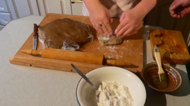 El Kneads bir hamur için Gingerbread geleneksel aile akşam yemeği insanlar bir ahşap kalıp aile ile bir Ram-Shaped kurabiye masada yemek yapıyoruz