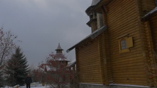 Hölzerne Kirchtürme Silhouetten Mann isst Beeren bei xvii Jahrhundert orthodoxen Kloster Kirchhof Skit aller Heiligen viburnum Busch ist das Symbol der Ukraine — Stockvideo