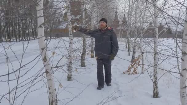 Hombre caminando a través de abedules Hablando de anfitrión programa de televisión frente a la cámara toca las ramas turísticas disfruta de una impresionante vista de la Iglesia Ortodoxa Antigua — Vídeo de stock