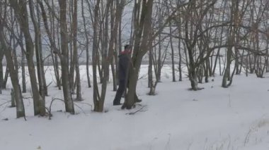 Çıplak dal yürüyen adam izlerken Sviatogorskaya Lavra ahşap kilise yol yol fırtınalı bulutlu ayaz akşam kış Snowy sokakta ağaçlar
