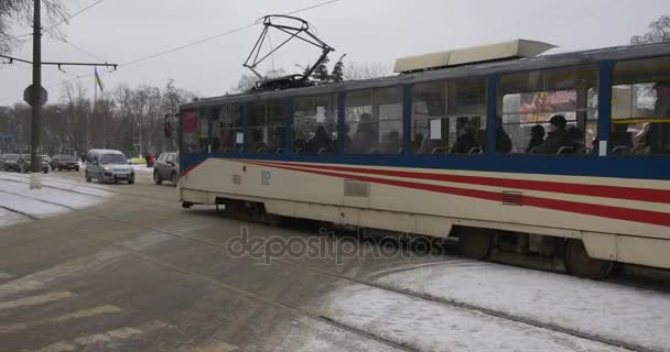 Ruch w Konotop mijając gołymi Road Konotop małych wojewódzkiego miasta w ziemi śnieżna zima, drzew i budynków wieczór View spacerem przez ulicę nowy tramwaj — Wideo stockowe