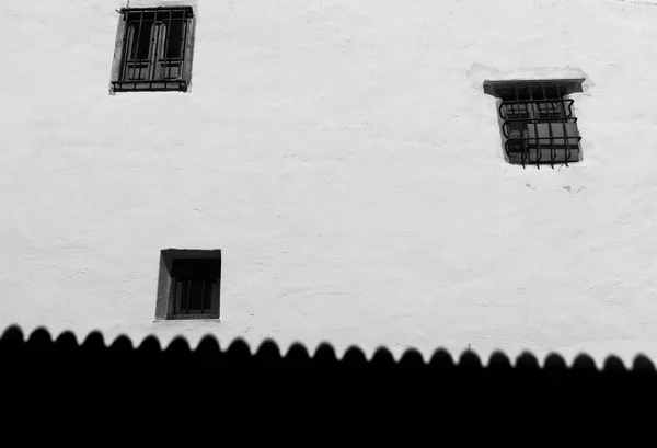 Três janelas na parede branca e sombra do telhado ao longo da base . — Fotografia de Stock