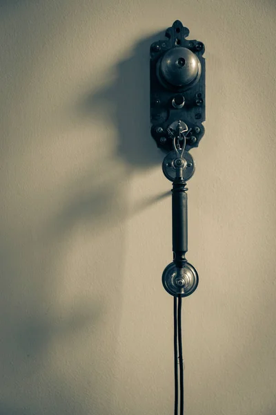 Imagem monocromática irritante de telefone antigo pendurado na parede — Fotografia de Stock