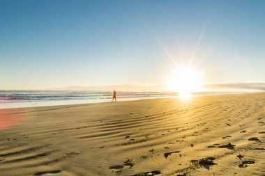 Ohope Whakatane, geniş düz kumlu plaj üzerinde gündoğumu