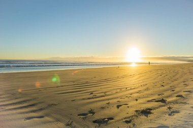 Ohope Whakatane, geniş düz kumlu plaj üzerinde gündoğumu
