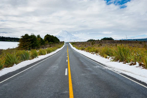Longue ligne centrale jaune le long de la route à travers le paysage hivernal — Photo