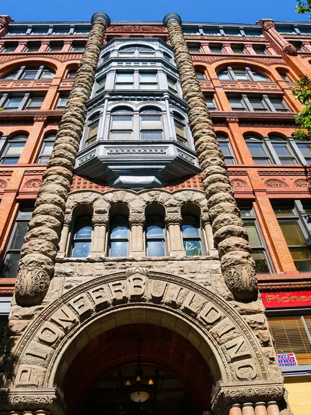 Low angle view of ornate red brick and concrete Pioneer Building — Stock Photo, Image