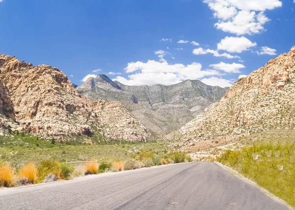 Route se dirigeant vers canon entre les collines environnantes dans le désert de Rouge — Photo