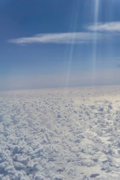 Lens flare in blauwe hemel boven witte puffy wolken in verticale comp — Stockfoto