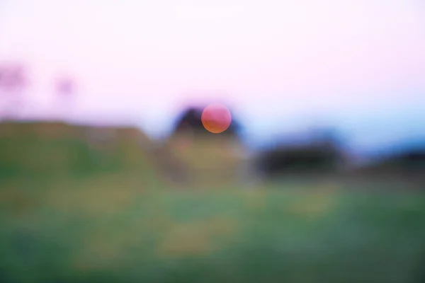 Sunrise abstrakta landskap gröna fält och skjul i oskärpa. — Stockfoto
