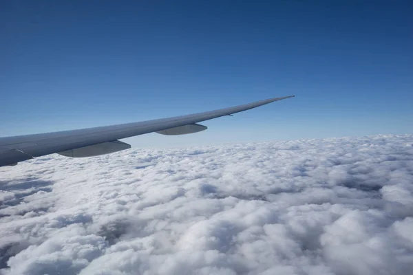 Vliegtuig vleugel boven wolk onder duidelijke blauwe hemel. — Stockfoto