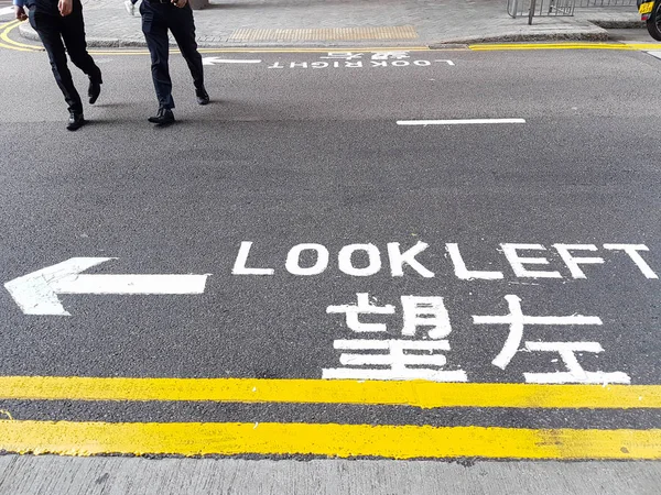 Insegna inglese e cinese "Look Left" sulla strada di Hong Kong . — Foto Stock