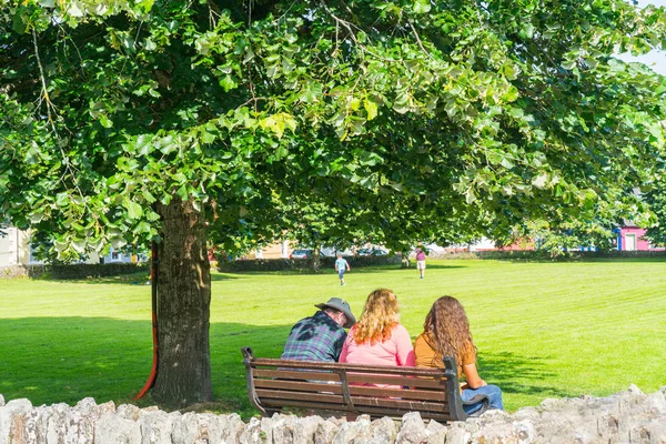 公園のベンチに座っている 3 人を背面します。 — ストック写真