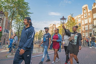 group young black tourists walking around the city taking a phot