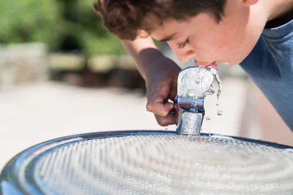Garçon à la fontaine d'eau profiter d'une boisson fraîche — Photo